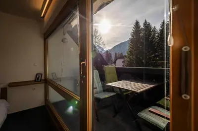 a room with a balcony with a table and a window at Riversound in Kranjska Gora