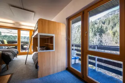 a room with a bed and a large window at Riversound in Kranjska Gora