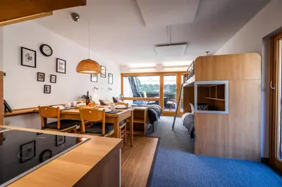 a kitchen and a living room with a table and a dining room at Riversound in Kranjska Gora