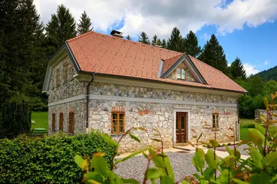 a small stone house with a red roof at Four-Bedroom Villa Bajer in Stari Trg pri Ložu