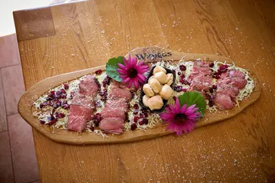 a plate of meat and flowers on a table at Four-Bedroom Villa Bajer in Stari Trg pri Ložu
