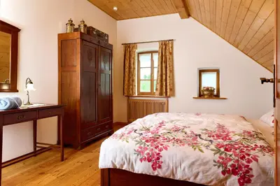 a bedroom with a bed and a wooden dresser and a bed sidx sidx sidx at Four-Bedroom Villa Bajer in Stari Trg pri Ložu