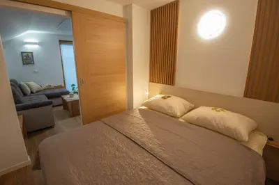 a bedroom with a bed with a mirror and a couch at Vineyard cottage Majolka in Novo Mesto