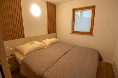 a small bedroom with a bed and a window at Vineyard cottage Majolka in Novo Mesto