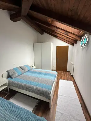 a bedroom with a bed and a wooden ceiling at Apartma Popeye in Bovec