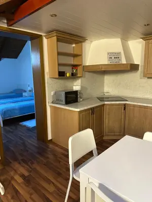 a kitchen with wooden cabinets and a table and chairs at Apartma Popeye in Bovec