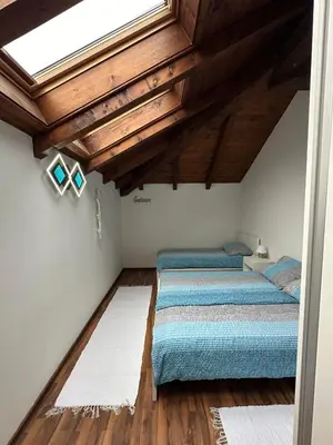 two beds in a room with a skylight at Apartma Popeye in Bovec
