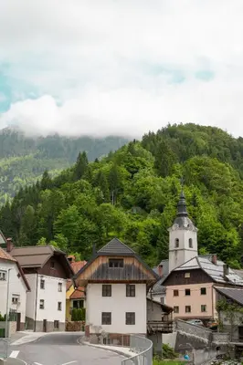 a small town with a church and a mountain at Hiša Juliana - Perfect Starting Point To Explore Slovenia in Podbrdo