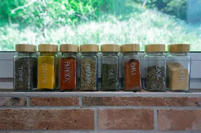 a row of glass jars of spices on a brick shelf at Hiša Juliana - Perfect Starting Point To Explore Slovenia in Podbrdo