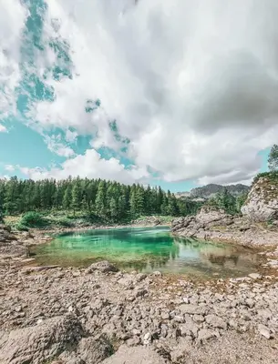 a pool of emerald green water on a rocky shore at Hiša Juliana - Perfect Starting Point To Explore Slovenia in Podbrdo