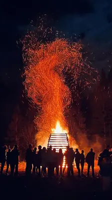 a group of people standing around a bonfire at night at Hiša Juliana - Perfect Starting Point To Explore Slovenia in Podbrdo