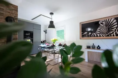 a living room with a table with a zebra picture on the wall at Hiša Juliana - Perfect Starting Point To Explore Slovenia in Podbrdo