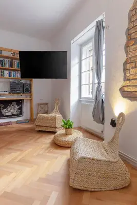 a living room with two chairs and a flat screen tv at Historical Caserne Apartment in Ljubljana
