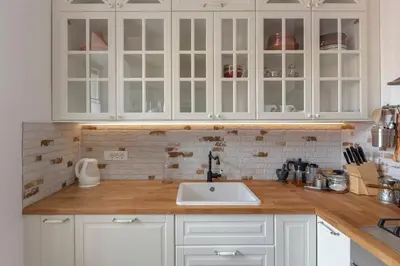 a kitchen with white cabinets and a sink at Historical Caserne Apartment in Ljubljana