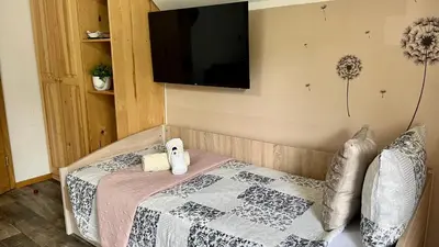 a bedroom with a bed and a flat screen tv at Apartma Jurka in Podčetrtek