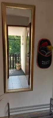 a mirror on a wall with a reflection of a room at Apartma Jurka in Podčetrtek
