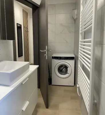 a bathroom with a washing machine and a sink at Homestead - Domačija - Nabergoj in Podnanos