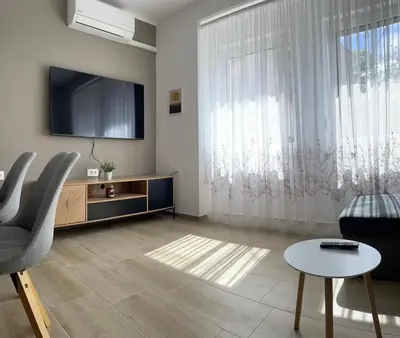 a living room with a television and a table and chairs at Homestead - Domačija - Nabergoj in Podnanos