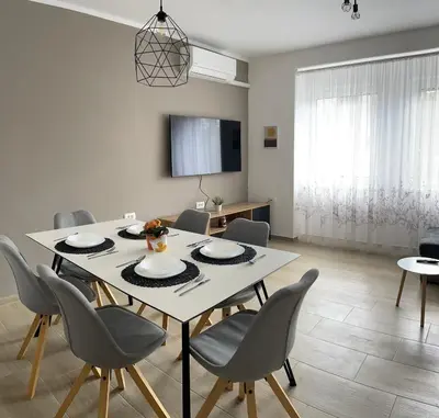 a dining room with a white table and chairs at Homestead - Domačija - Nabergoj in Podnanos