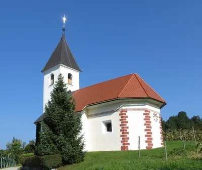 a small white church with a red roof at Zidanica Vidrih in Dolenjske Toplice