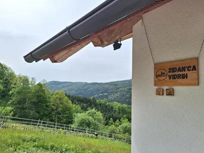 a sign on the side of a building with a mountain at Zidanica Vidrih in Dolenjske Toplice