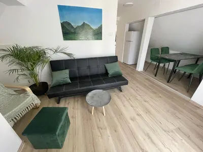 a living room with a black couch and a table at Apartma Tonii in Bovec