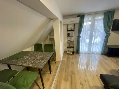 a dining room with a table and green chairs at Apartma Tonii in Bovec