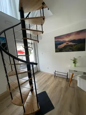 a wooden spiral staircase in a living room at Apartma Tonii in Bovec
