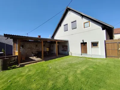a view of a white house with a yard at MaLu vintage house with garden in Logatec