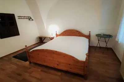 a bedroom with a wooden bed and a table at MaLu vintage house with garden in Logatec
