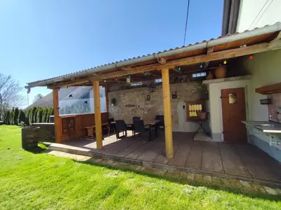 a wooden patio with a table and chairs at MaLu vintage house with garden in Logatec