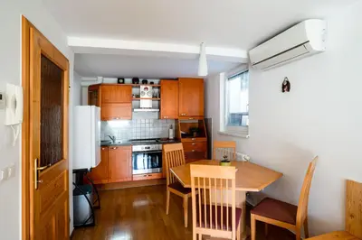 a kitchen with wooden cabinets and a wooden table at Apartma Pokljuška idila - Idyllic Pokljuka Studio above Bled in Bled