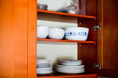 a cabinet filled with plates and bowls and dishes at Apartma Pokljuška idila - Idyllic Pokljuka Studio above Bled in Bled