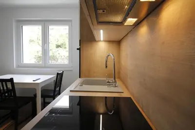 a kitchen with a sink and a table and a window at Naia Apartments in Novo Mesto