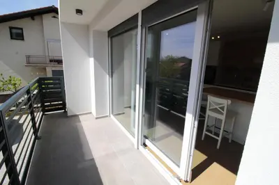 a balcony with sliding glass doors on a building at Naia Apartments in Novo Mesto