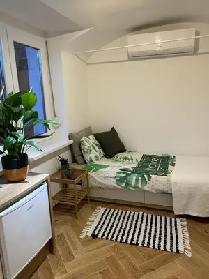 a small bedroom with a bed and a window at GG art apartments III in Ljubljana