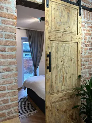 an open wooden door in a bedroom with a bed at GG art apartments III in Ljubljana