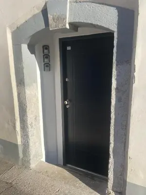 a black door in a building with a stone wall at GG art apartments III in Ljubljana
