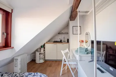 a room with a staircase with a desk and a kitchen at Stylish Loft In The Hearth Of Historic Centre in Ljubljana