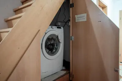 a washer and dryer in a room with stairs at Stylish Loft In The Hearth Of Historic Centre in Ljubljana
