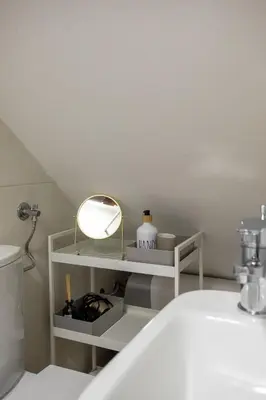 a bathroom with a sink and a mirror on a shelf at Stylish Loft In The Hearth Of Historic Centre in Ljubljana