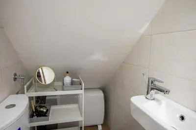 a white bathroom with a sink and a toilet at Stylish Loft In The Hearth Of Historic Centre in Ljubljana