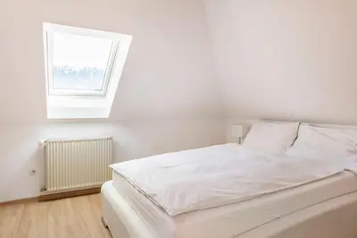 a white bed in a room with a window at Spacious And Historic Villa With Bled Castle View in Bled