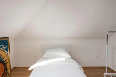 a white bed in a room with a white ceiling at Spacious And Historic Villa With Bled Castle View in Bled