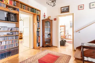 a living room with bookshelves and a room with a table at Spacious And Historic Villa With Bled Castle View in Bled