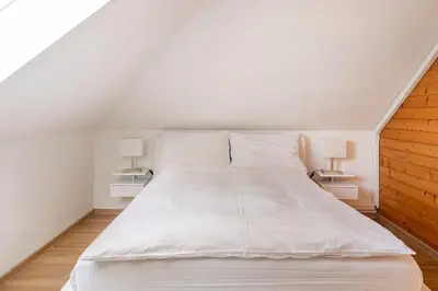 a white bed in a room with two lamps at Spacious And Historic Villa With Bled Castle View in Bled