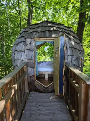 a bed in a cabin with a wooden bridge at T'glamp Bee house in Rovte