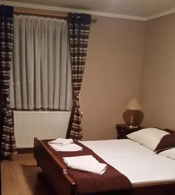 a bedroom with a bed and a window with curtains at Gostilna s prenocisci Danica in Slovenska Bistrica