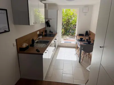 a kitchen with a sink and a table and a window at LiLan apartment in Maribor