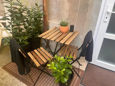 a table and two benches and plants on a porch at LiLan apartment in Maribor